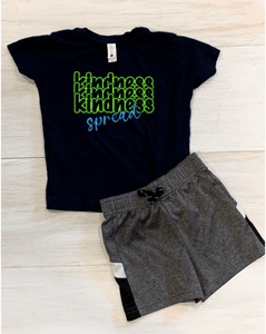 The word "kindness" stacked three times in neon green vinyl, the word "spread" in bright blue vinyl across the word "kindness" so that the shirt reads "spread Kindness"