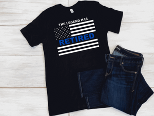 Black shirt. Wording at top states "the legend has retired.." Below is an american flag. In the middle of the flag is the word "retired" in bold blue vinyl