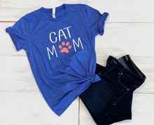 Load image into Gallery viewer, The word cat and the word mom below it with a paw print for the O on heather true coral shirt 
